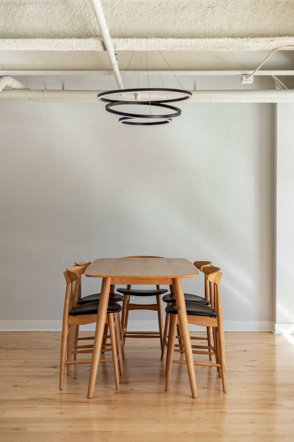 Modern dining room with light wood table and chairs.