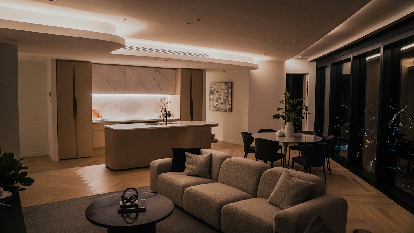 Modern apartment living room with modular sofa and city view.